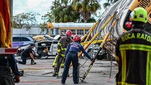 firefighters set up stabilizing equipment during a vehicle rescue simulation. 