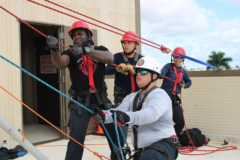 Firefighters working together to haul ropes. 