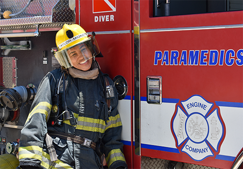 Student leaning against a fire truck